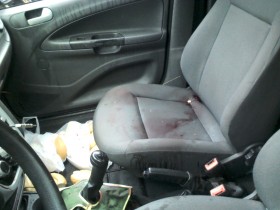 Manchas de sangue do assaltante ficaram no banco do carro.
