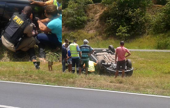 Carro capotou no canteiro central. No destaque ela sendo socorrida.