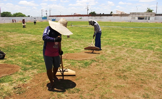 Equipe realiza correção no gramado.