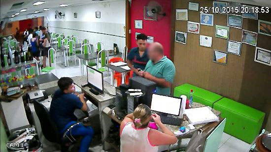Assaltante encosta uma arma no corpo do proprietário.