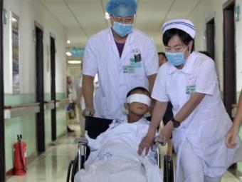Guo Bin é conduzido em cadeira de rodas por equipe médica de hospital em Taiyuan