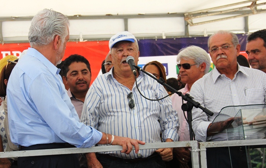 Nelsinho de cabelos alvos e óculos escuros e no direito do prefeito Roberto Carlos