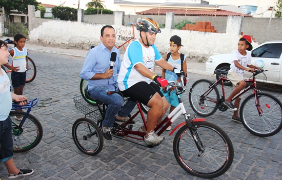 Jorge Araújo desfila pela rua na "garupa" da inusitada bike de Boba.