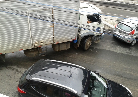Esse caminhoneiro ouviu muita buzina enquanto travou o trânsito. Dupla irregularidade o motorista do carro preto para numa esquina e mais a frente outro carro no ponto exclusivo para taxi.