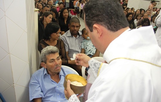 Momento que o padre serve a eucaristia a seu pai.
