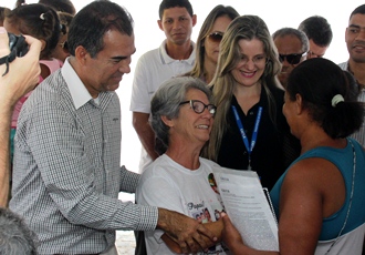 Prefeito Assis juntamente com Jussara viúva de Mário da Caixa homenageado entrega uma das chaves a nova moradora.