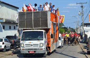 Bandeiras e cartazes com fotos de candidatos espalhados por todo desfile.