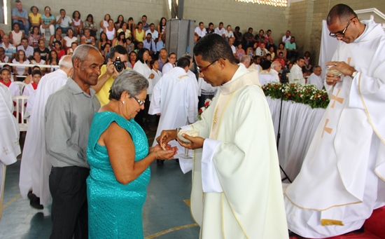 Mãe e pai os primeiros a receberem a eucaristia do novo vigário.