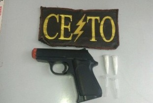 Arma de brinquedo apreendida com uma substância que pode ser cocaína.