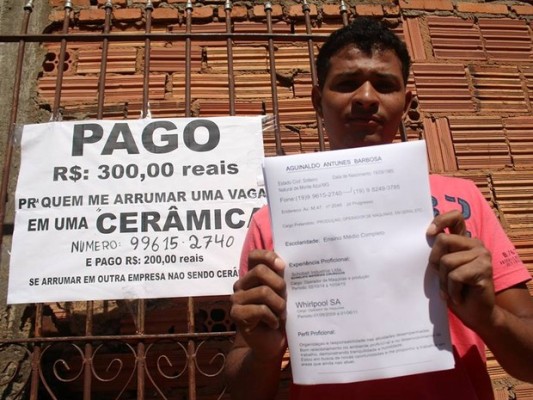 Aguinaldo Antunes ao lado do anúncio que colocou no portão de casa