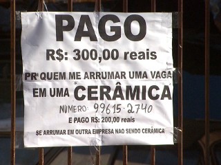 Aguinaldo Antunes ao lado do anúncio que colocou no portão de casa