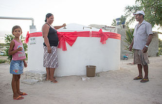 Dona de casa comemora recebimento de uma cisterna.