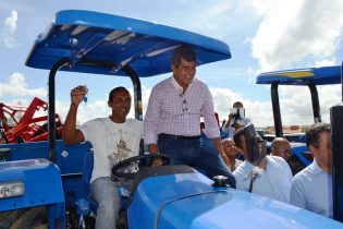 Gika Lopes ao lado de um líder comunitário que exibe a chave do trator