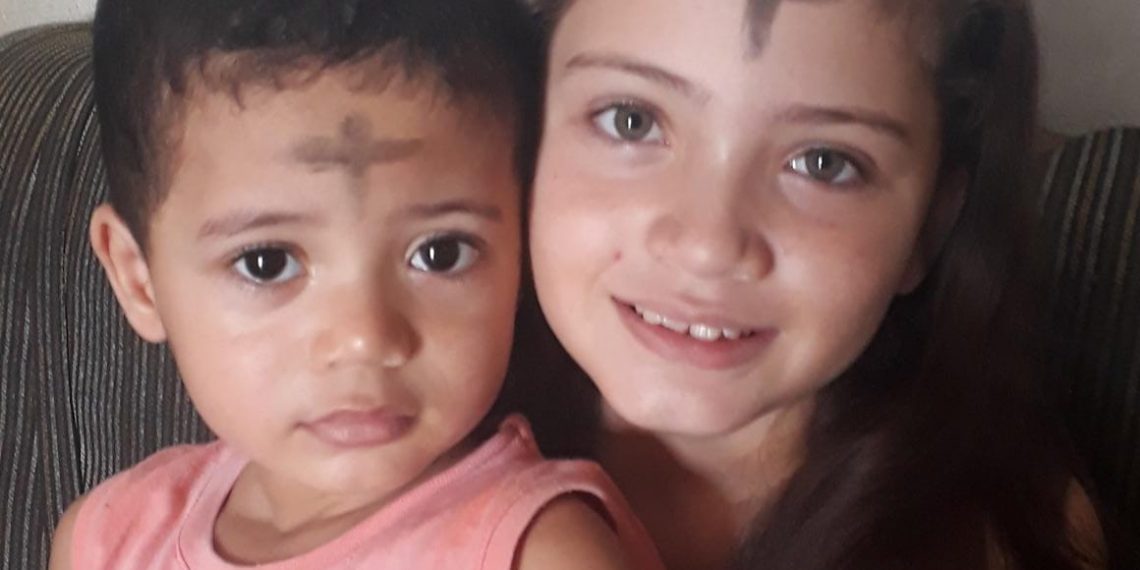 Mãe mantém tradição católica ao fazer a cruz na testa dos filhos para simbolizar o início da quaresma