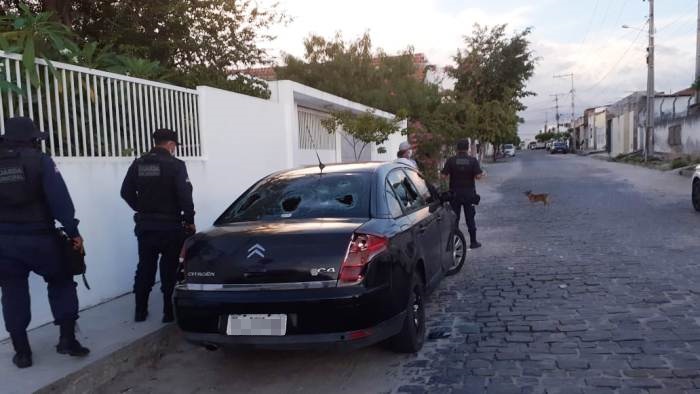 Carro com para-brisas, faróis e lanternas quebrados chama atenção das pessoas